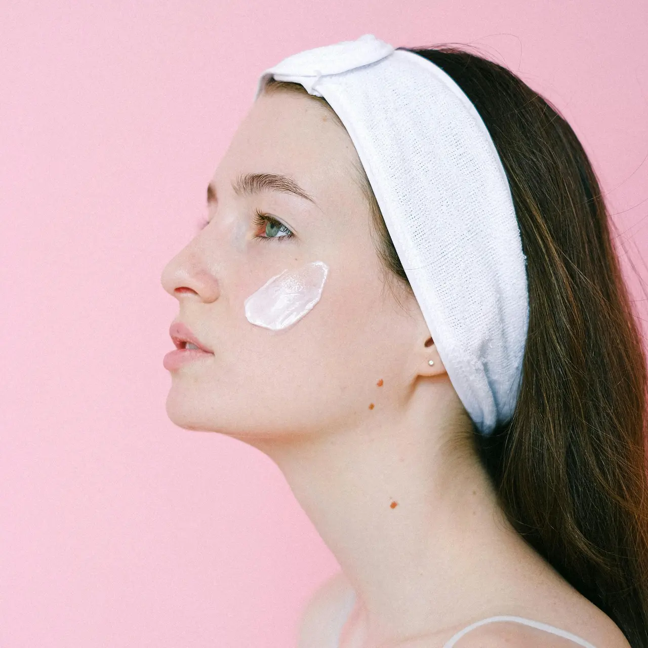 Kobieta z cerą tłustą aplikująca lekki krem nawilżający na twarz